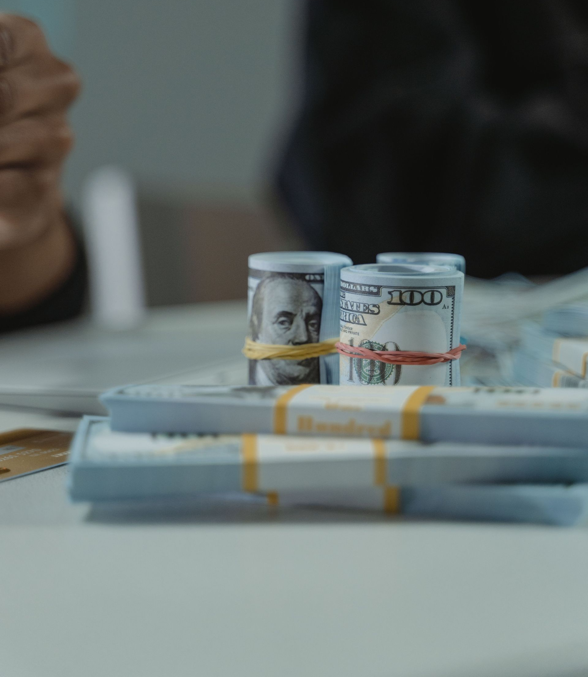 Rolled cash and documents representing the cost and budgeting involved in building a Vermont home.