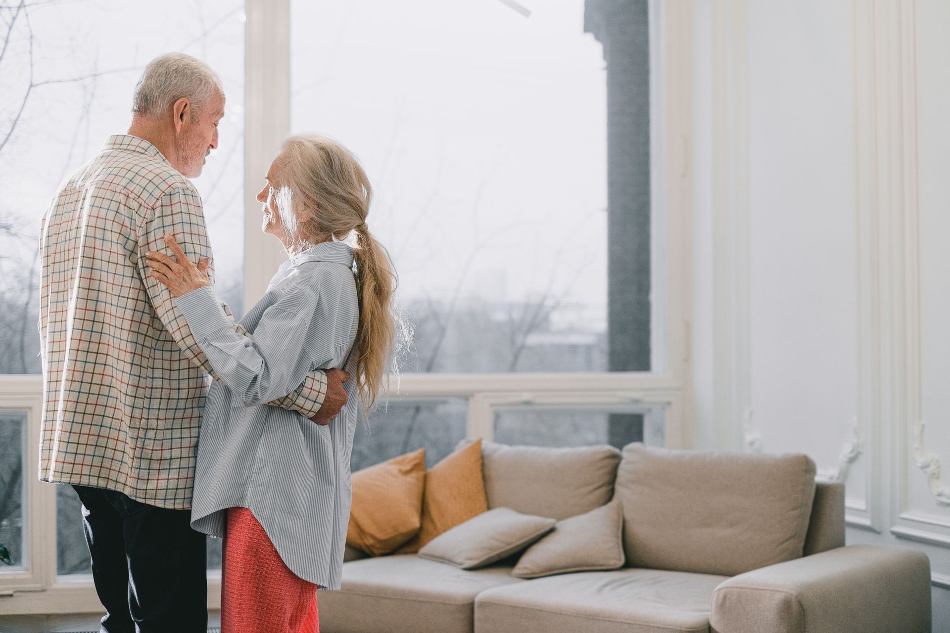 Older couple enjoying a bright, comfortable living room designed for aging in place.