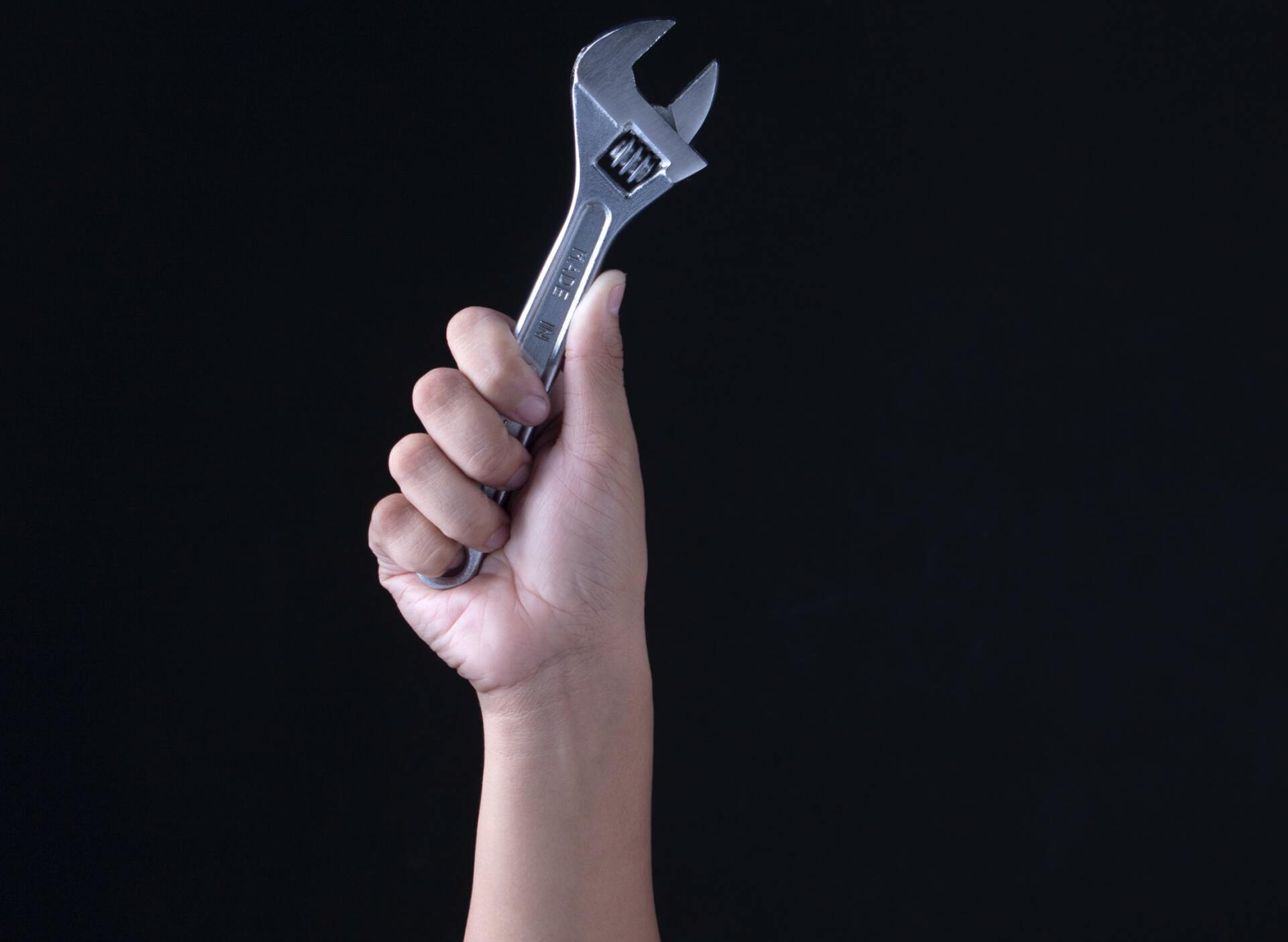 hand holding up a wrench
