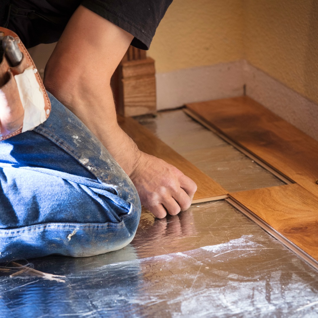 Contractor installing engineered wood flooring.