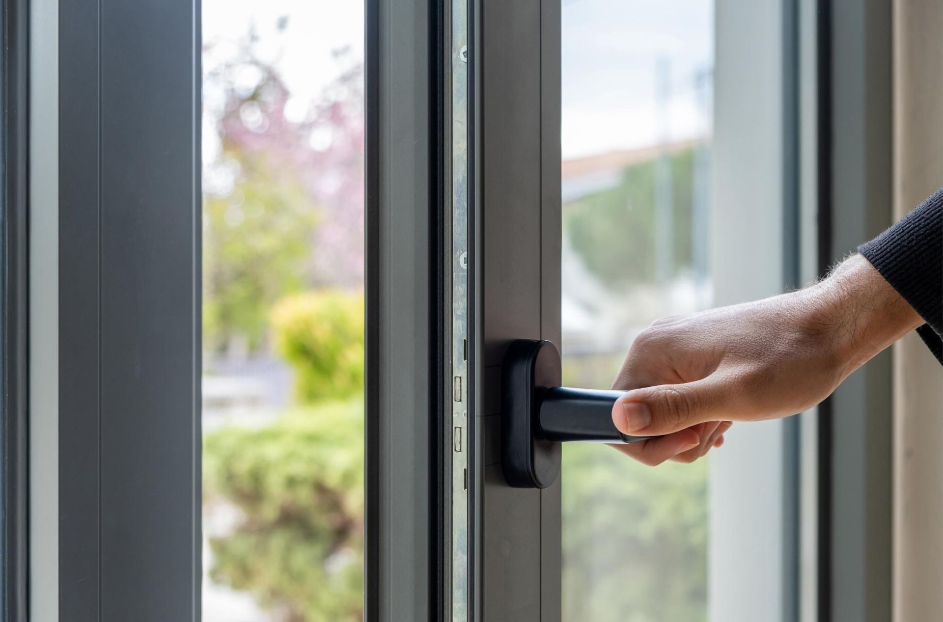 A Person Is Opening a Window with A Black Handle — Grafton Glass in South Grafton, NSW