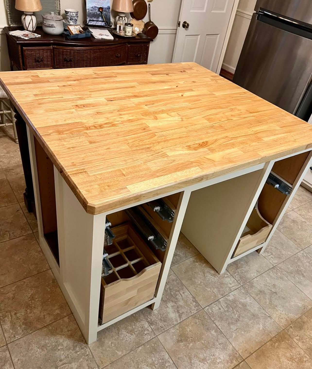 A wooden table with drawers underneath it in a kitchen.