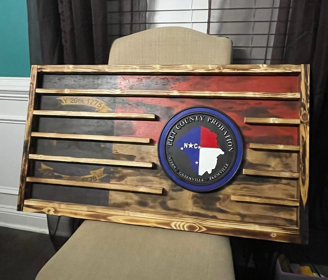 A wooden flag is sitting on top of a chair.