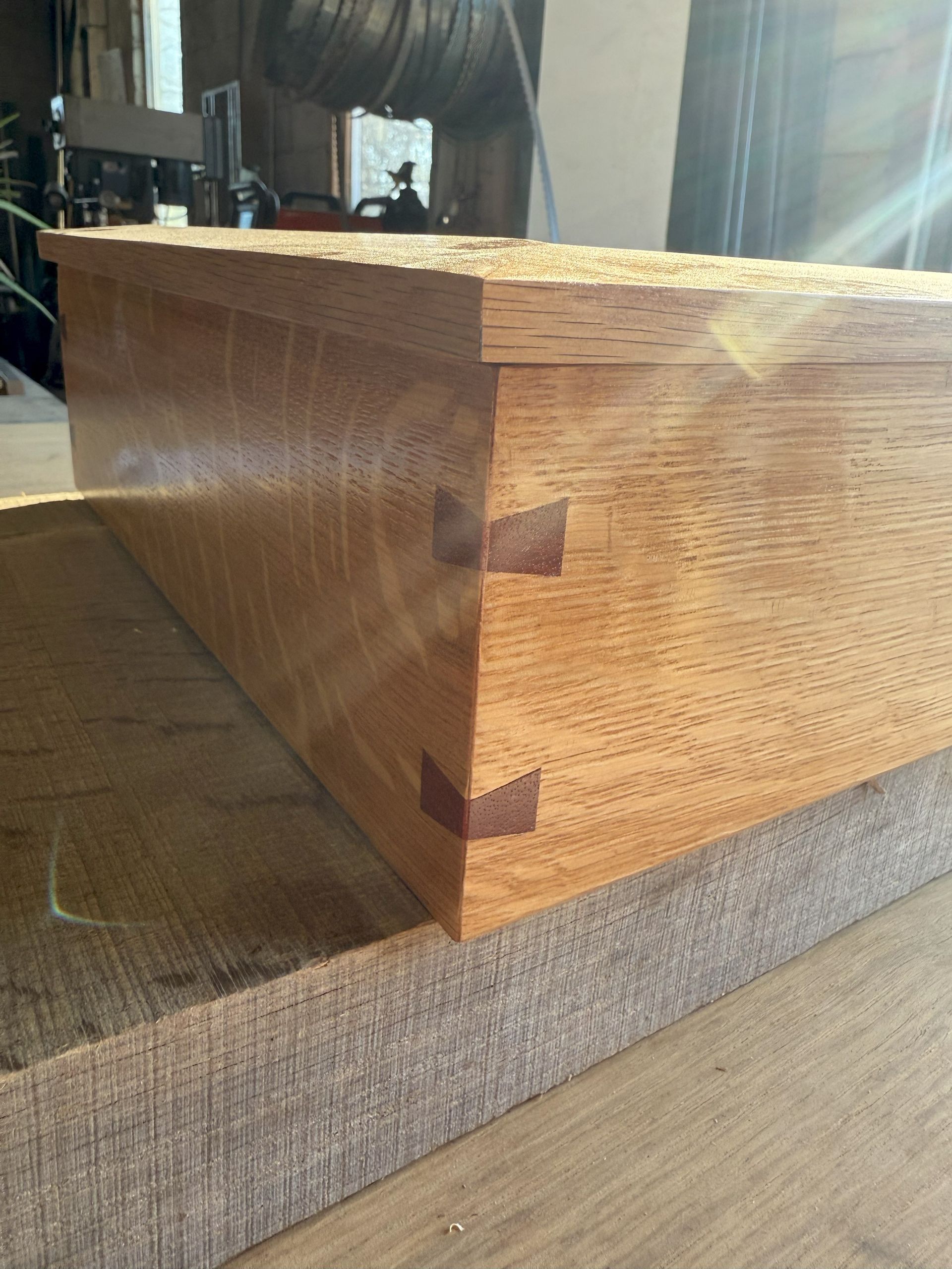 Close-up of a wooden dovetail joint on a furniture corner, showing smooth grain and joinery detail.
