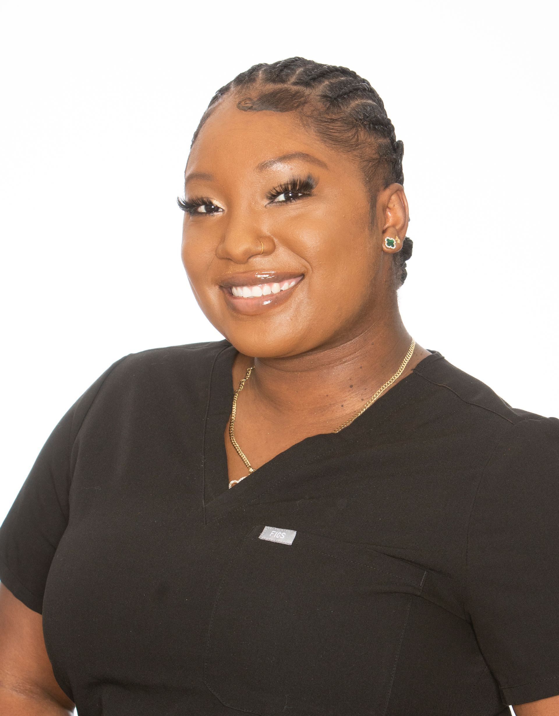 A woman in a black scrub top is smiling for the camera.