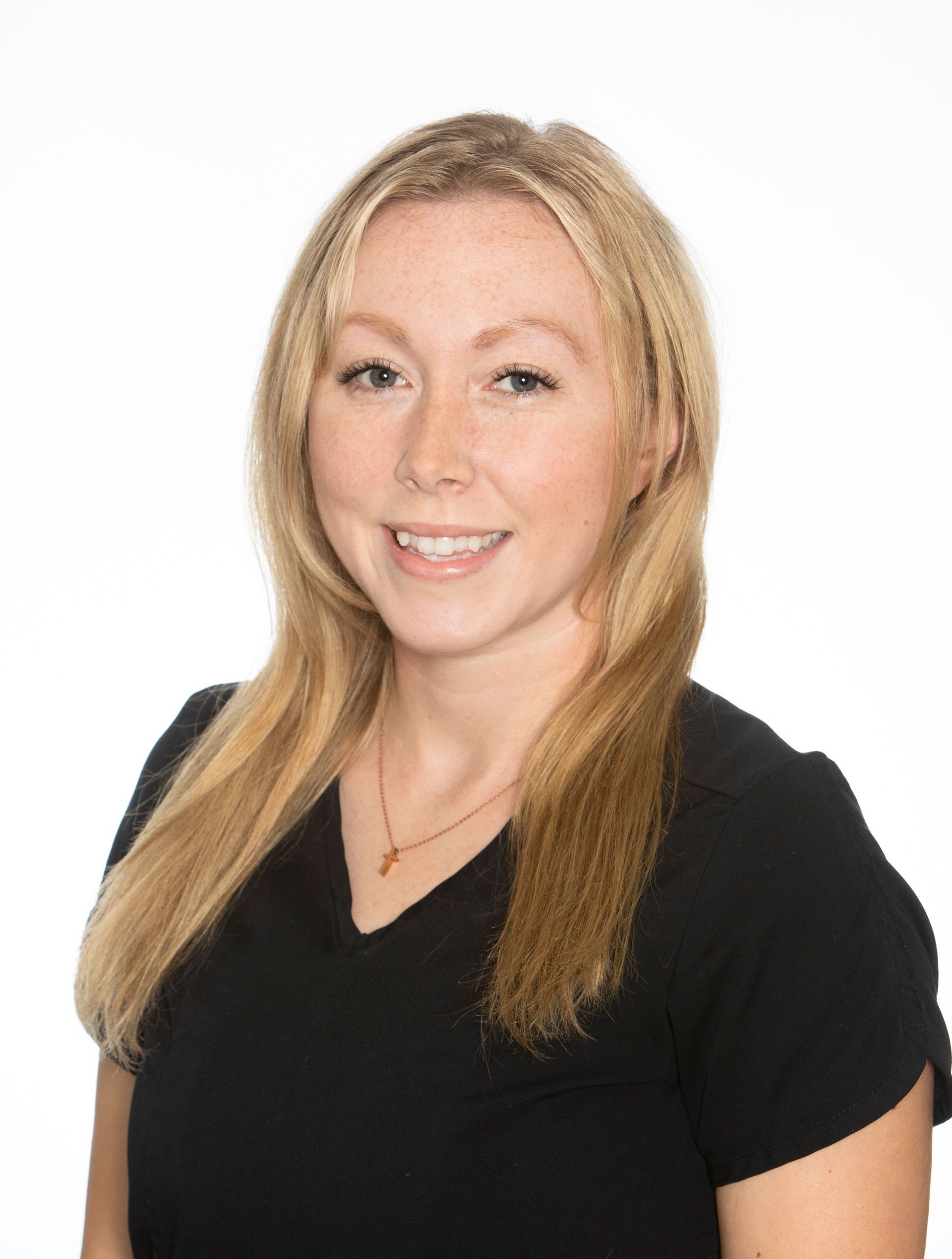 A woman with long blonde hair is wearing a black shirt and smiling.