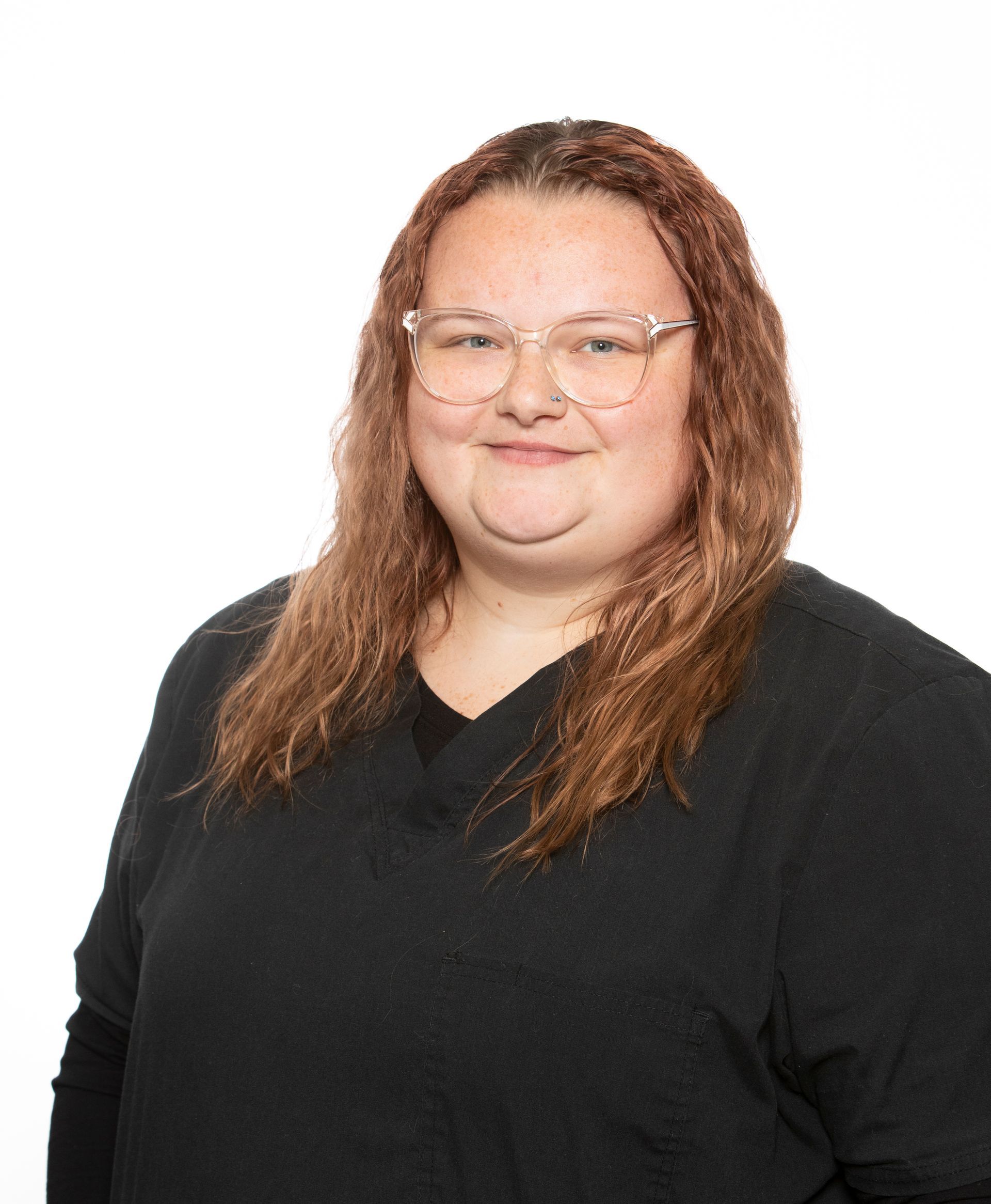 A woman wearing glasses and a black shirt is smiling for the camera.