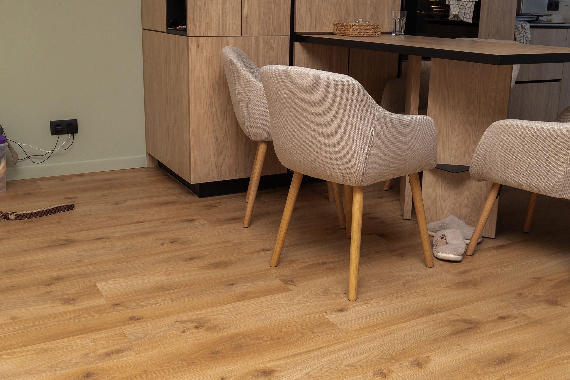 Modern dining area with wooden table, beige chairs, and light wood floor