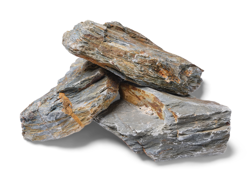 Three layered gray and brown rocks stacked on a white surface.