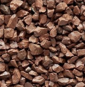 Red lava rock. Brown, irregularly shaped stones clustered together on a white surface.