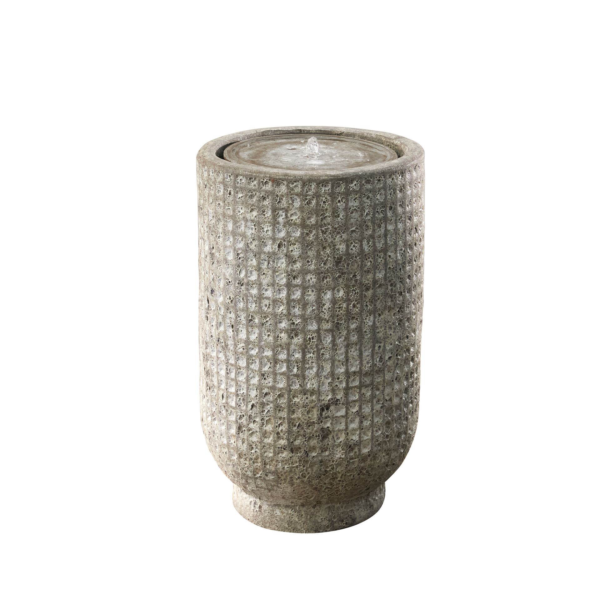 Stone water fountain with textured surface, water flowing from the top.