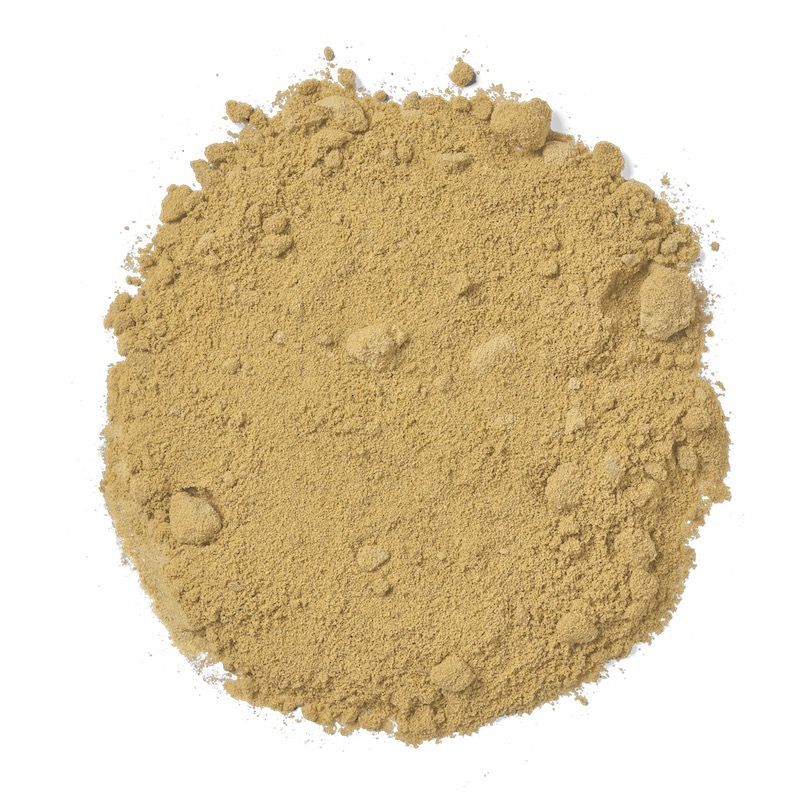 Pile of tan-colored powder, possibly a spice or supplement, on a white background.