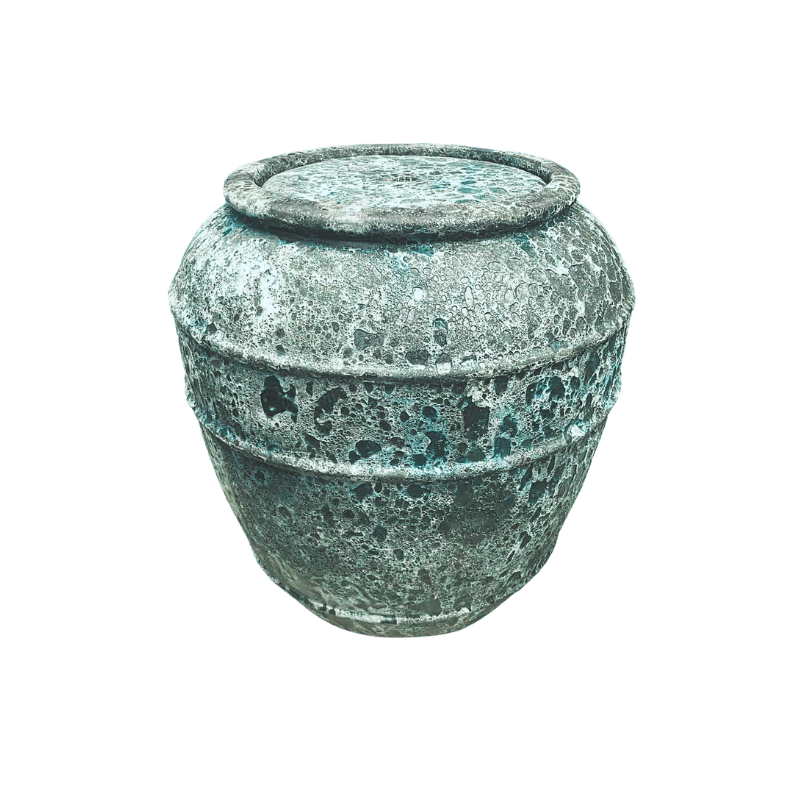 An antique, weathered jar with lid. Gray-green with textured surface.