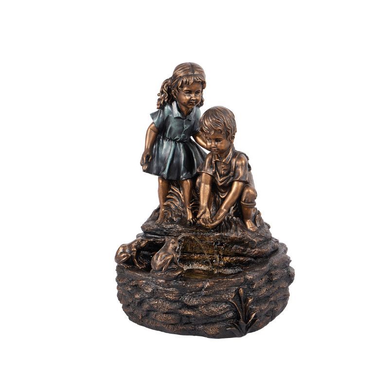 Fountain sculpture: Two children, one standing, one kneeling, play near water. Bronze color, outdoors.