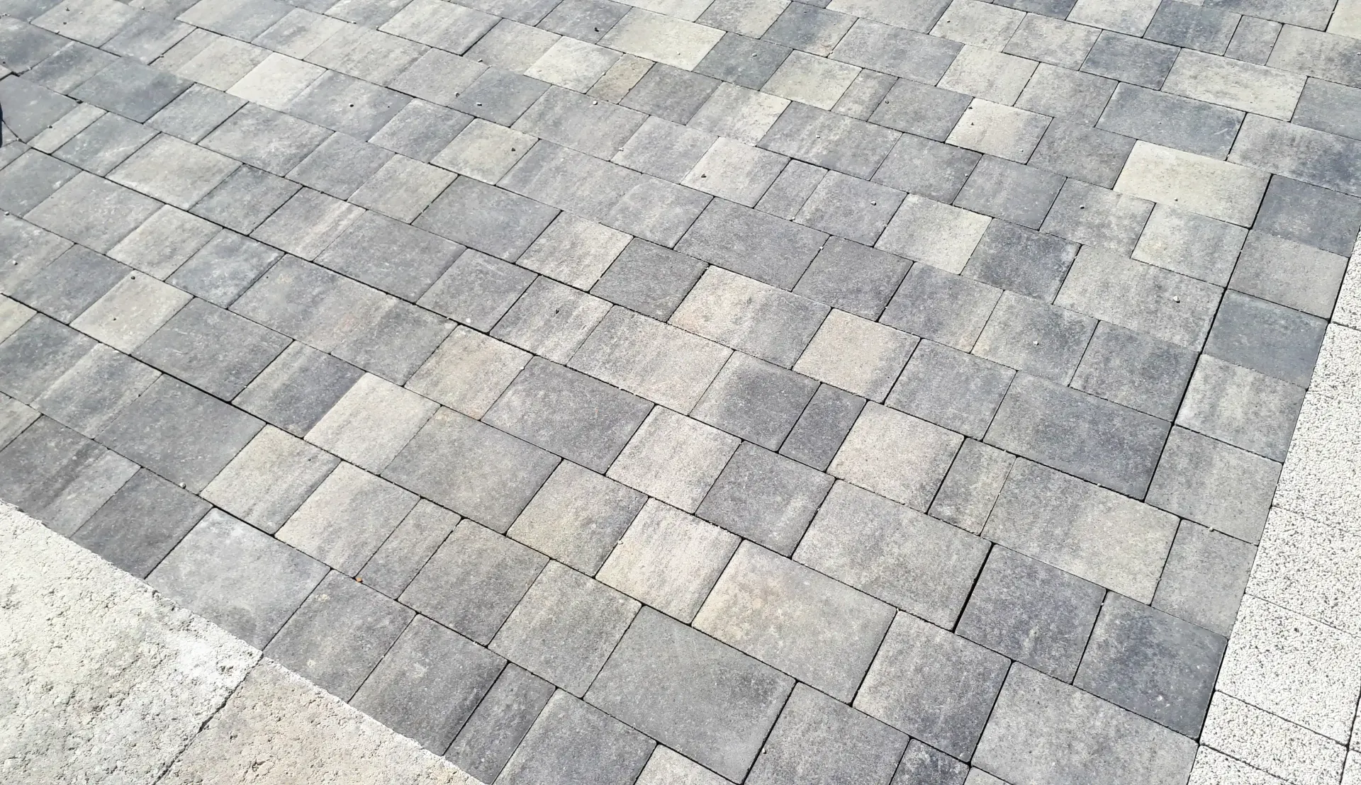 Gray stone paver sidewalk with a mottled, irregular pattern
