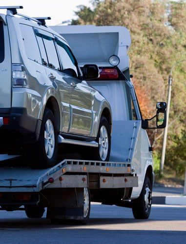A car is being towed by a tow truck.