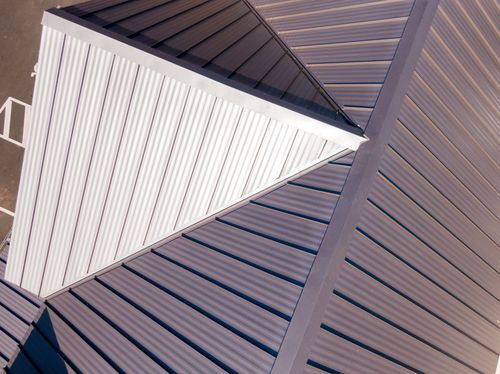 Abstract geometric rooftop with a white triangular skylight against brown slatted panels