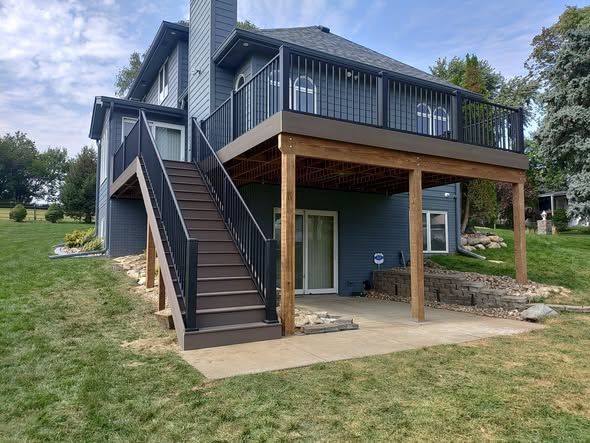 Two-story house with blue siding, a wooden deck, and a stairway.