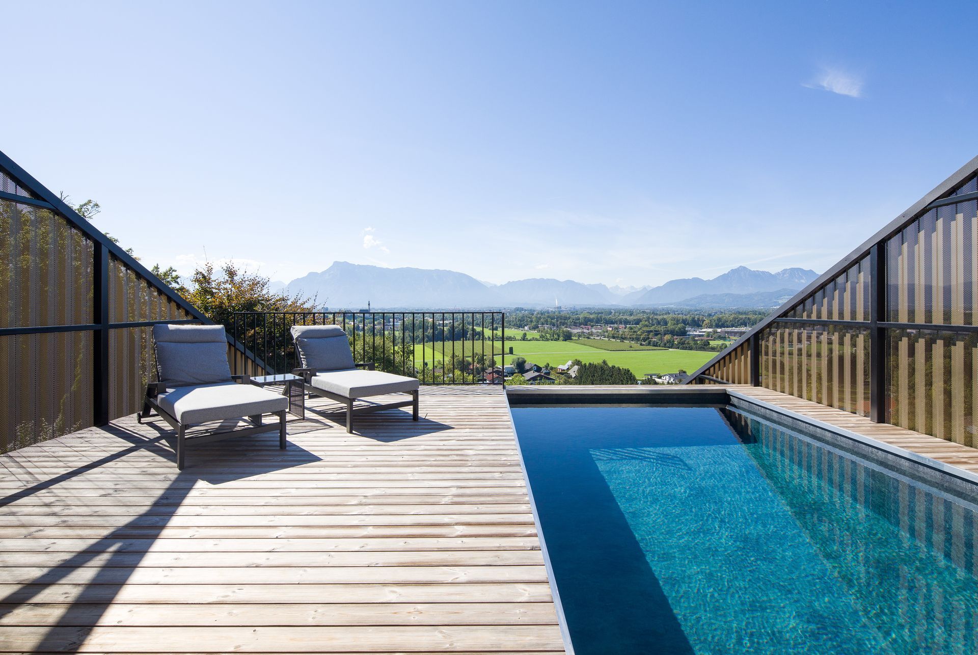 Ein Swimmingpool, umgeben von Stühlen und einem Holzdeck