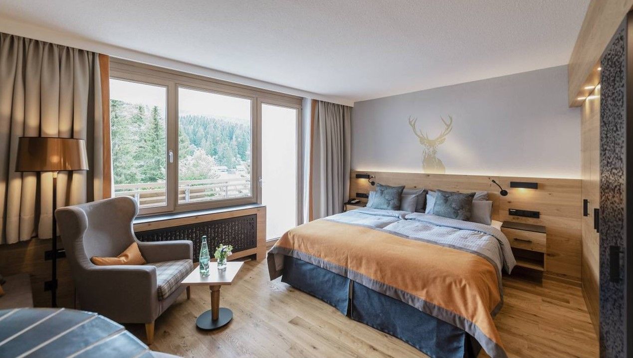 Ein Hotelzimmer mit einem großen Bett und einem Stuhl