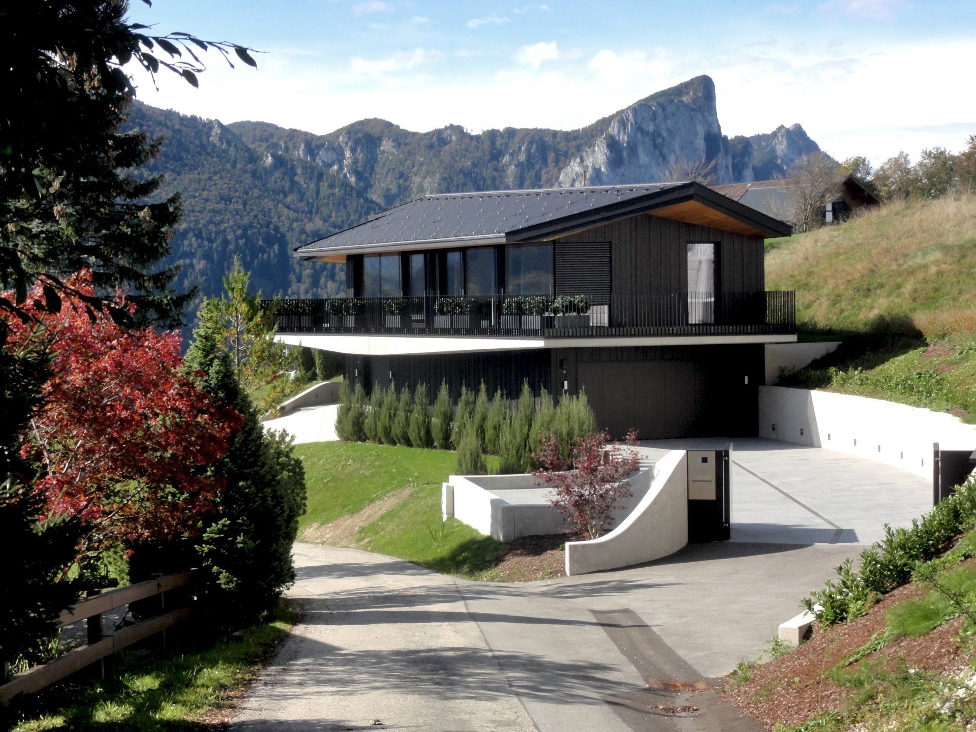 Ein Haus auf einem Hügel mit Bergen im Hintergrund