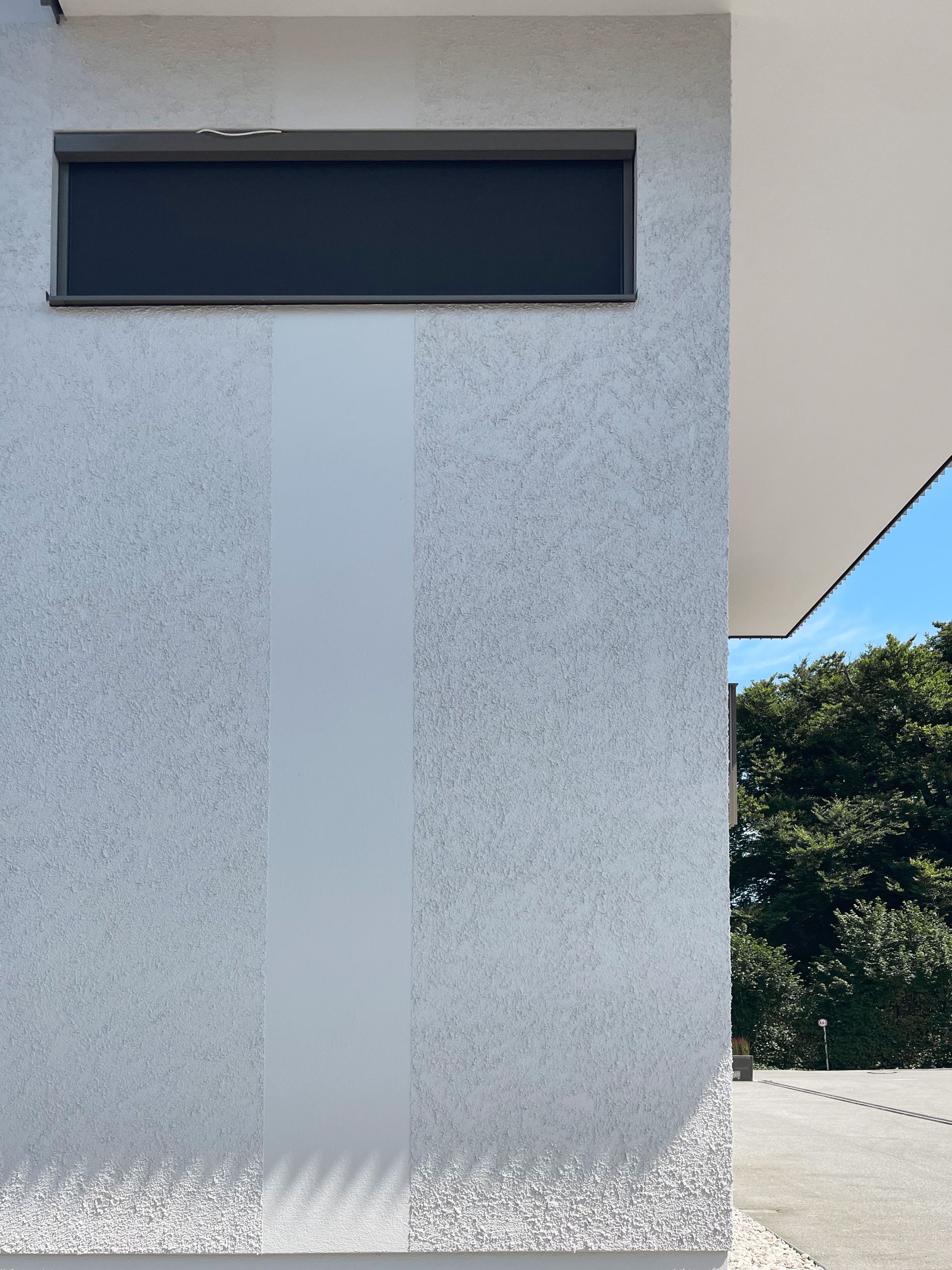 Eine weiße Wand mit einem schwarzen Fenster darauf