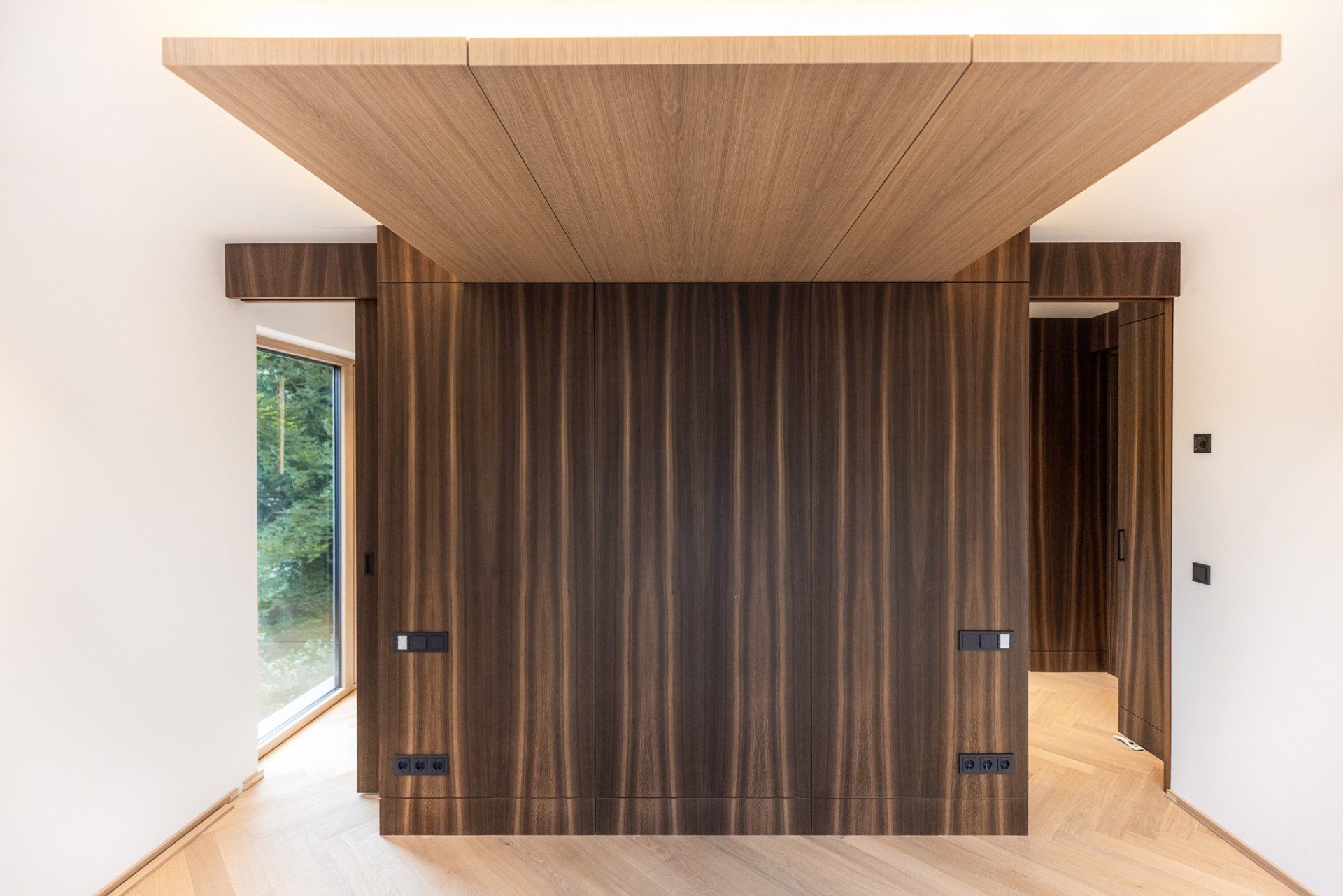Ein Raum mit einer Holzwand und einem Fenster