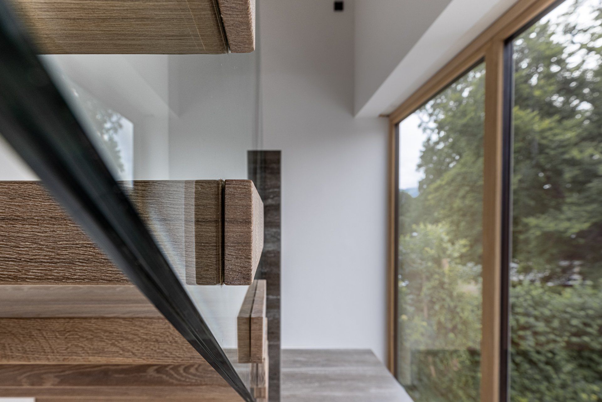 Eine Treppe mit Glasgeländer und großem Fenster