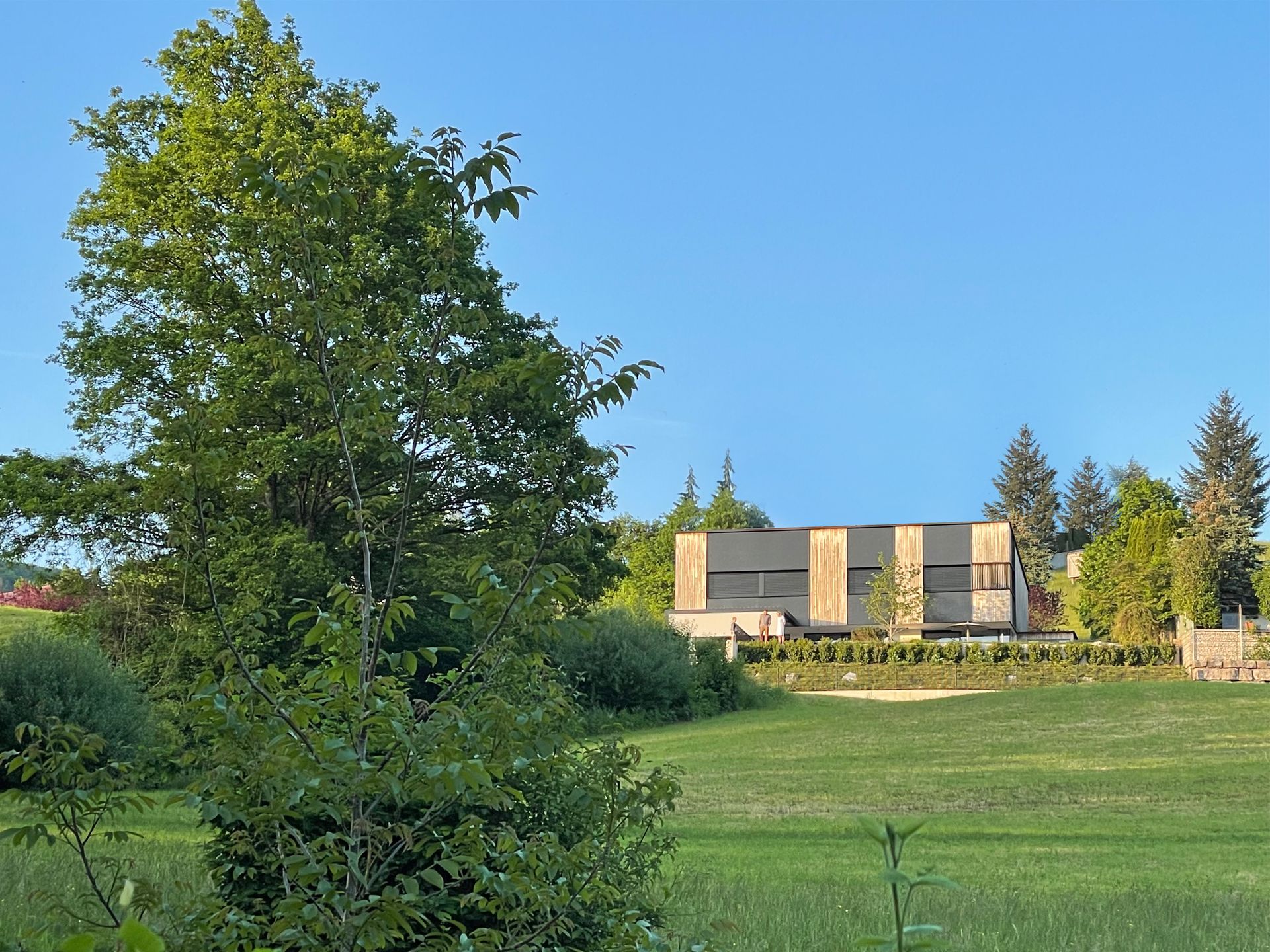 Ein Haus liegt inmitten eines üppigen grünen Feldes
