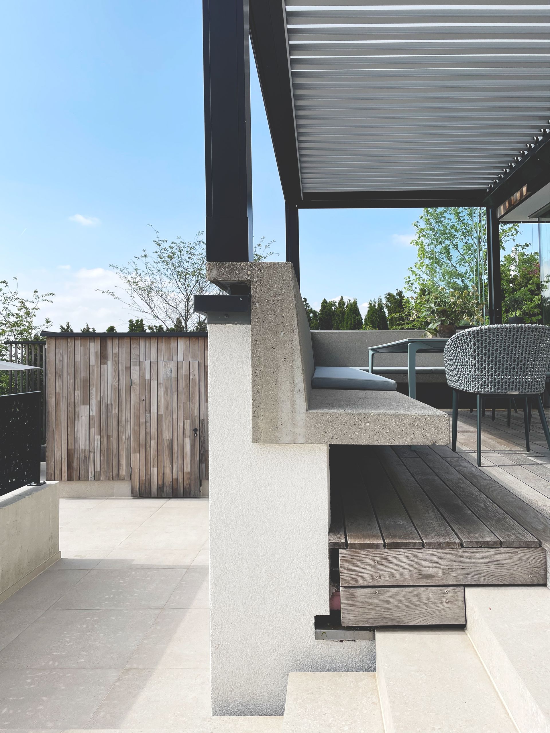 Eine Treppe, die zu einer Terrasse mit einem Holzzaun im Hintergrund führt