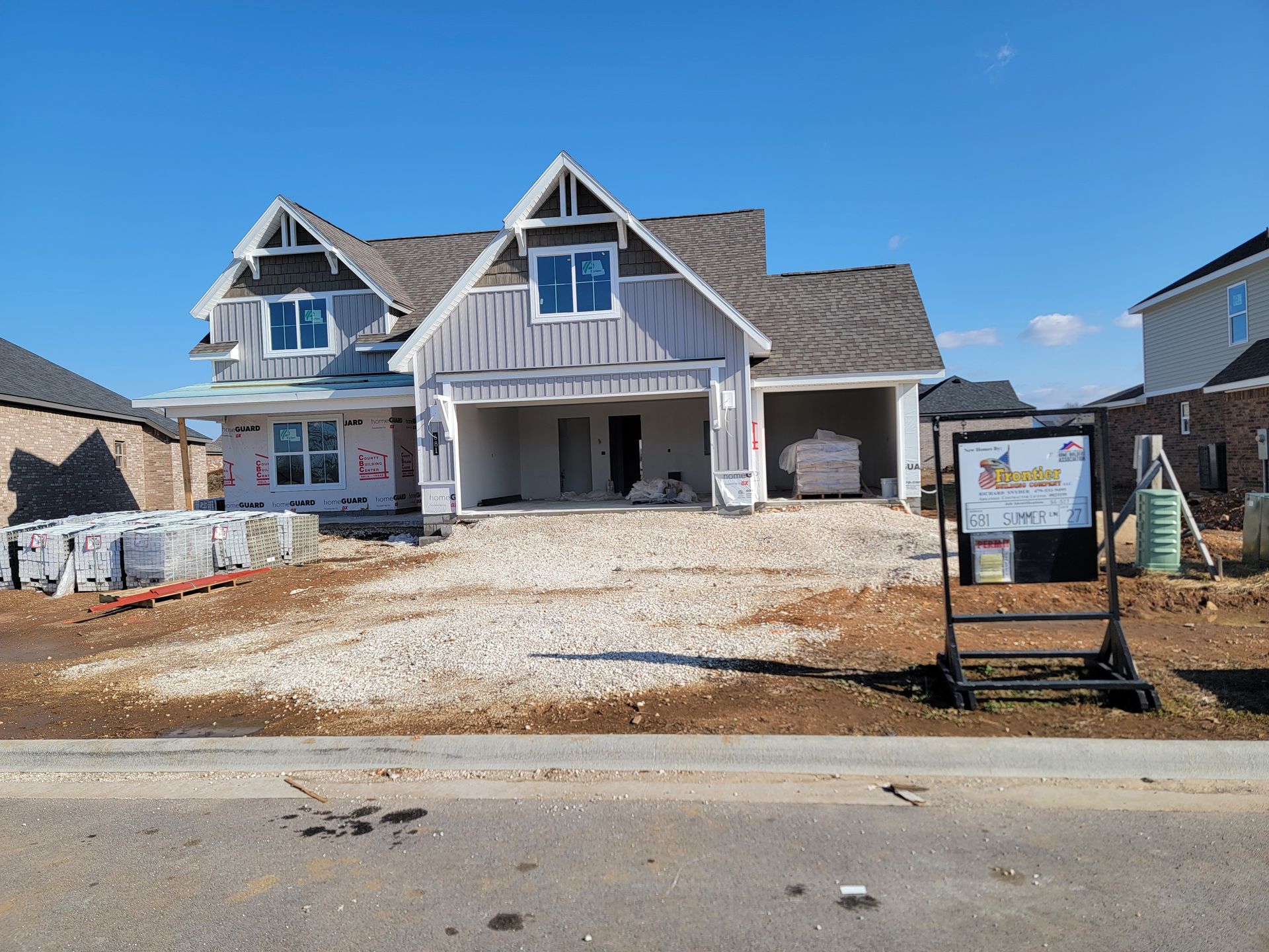 New house under construction with a partially finished front porch and driveway sign