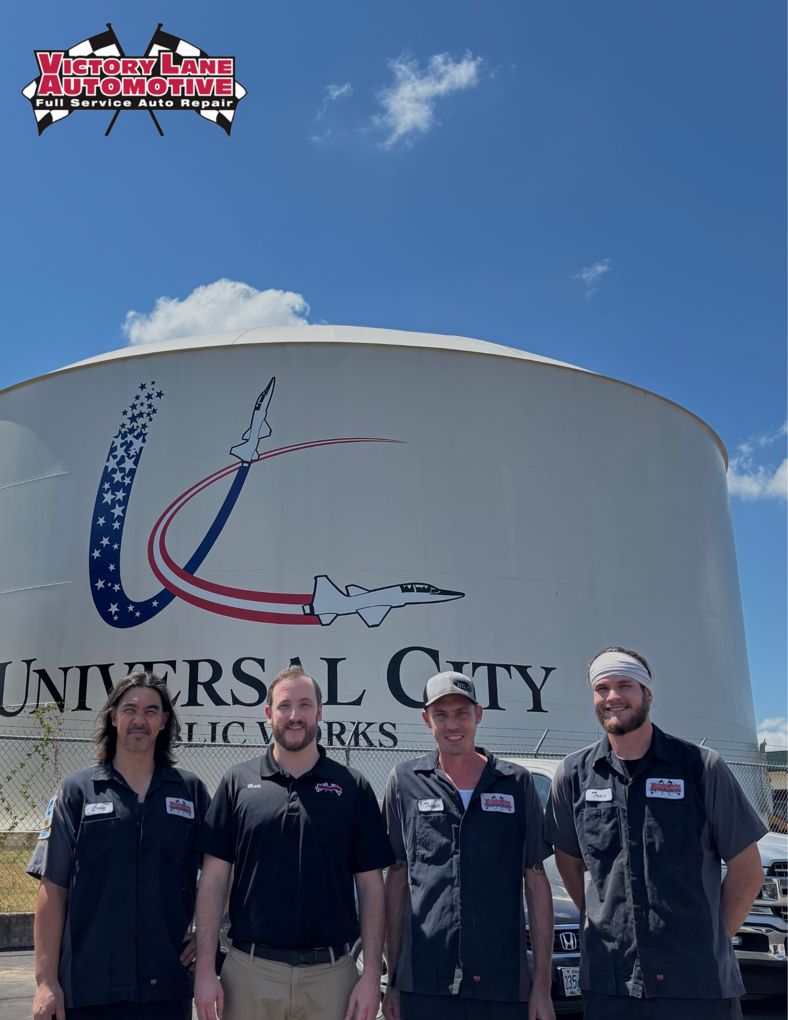 Four people stand in front of a Universal City Public Works water tower under a blue sky. | Victory Lane Automotive