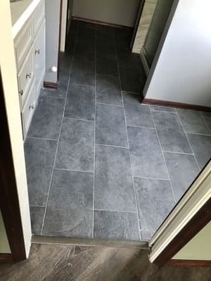 Small hallway with dark gray tile floor and white walls, viewed through a doorway.