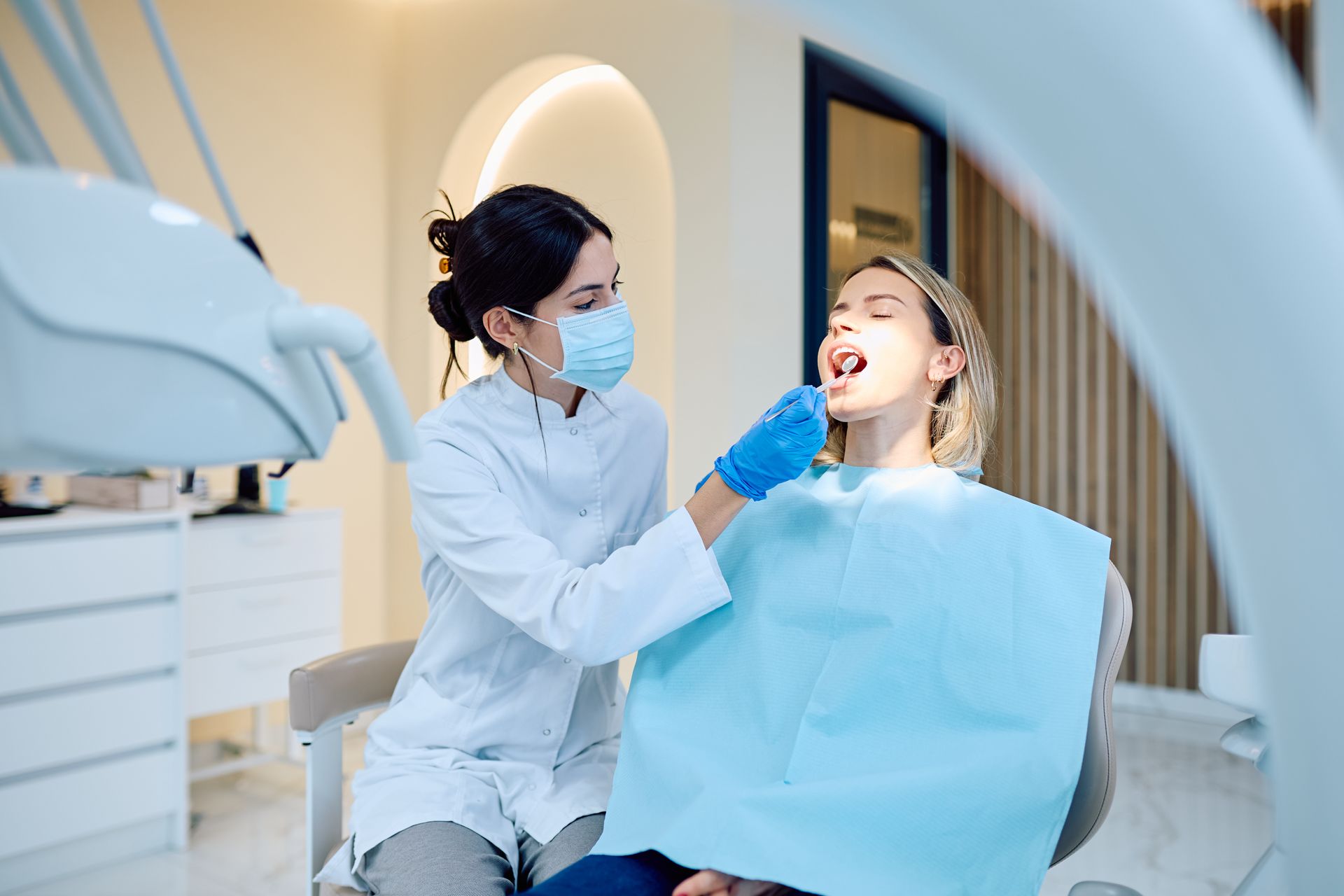 A dentist is checking the mouth of a patient. A dentist is checking the mouth of a patient.