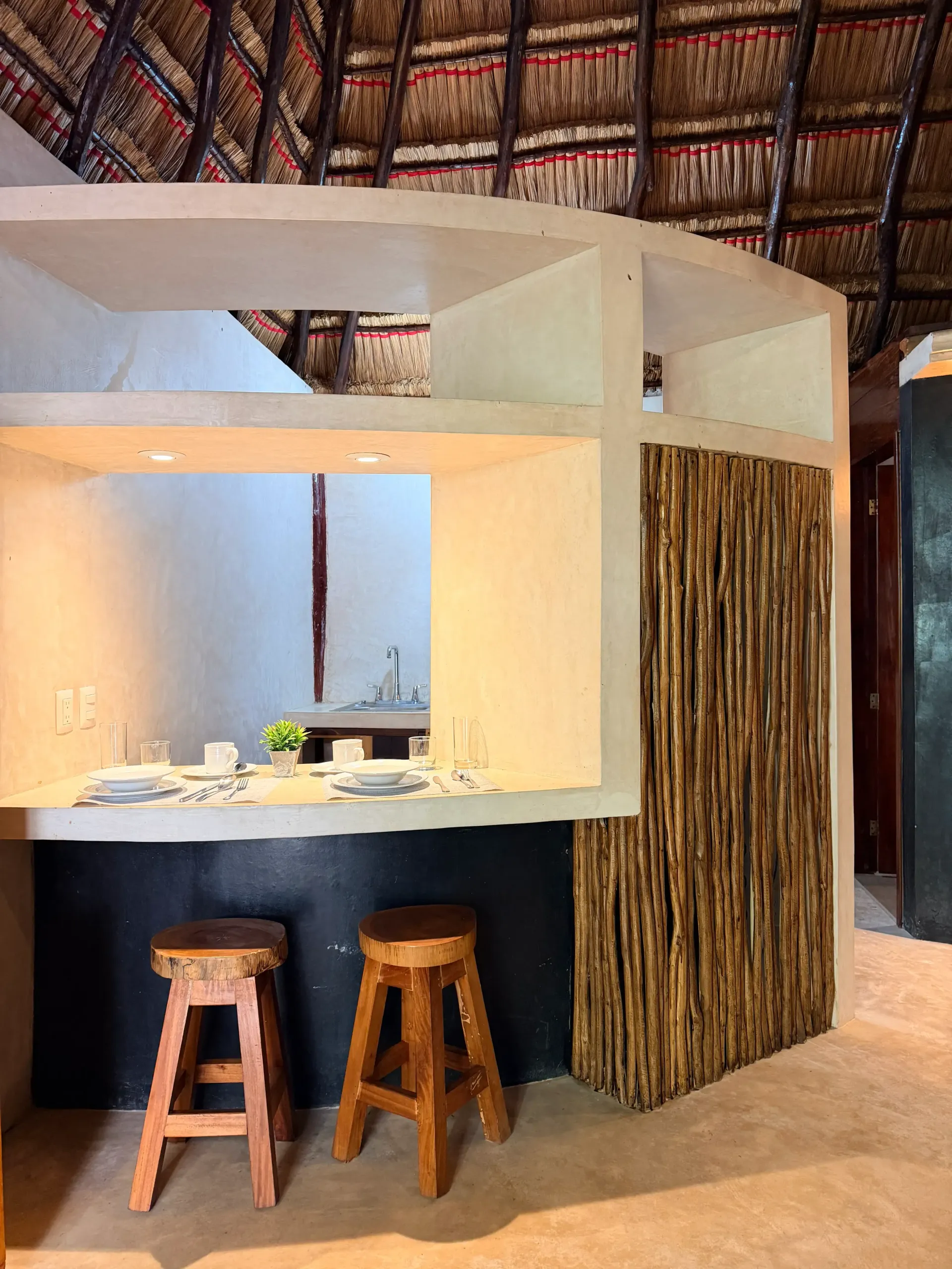 Modern thatched bar nook with two stools and woven wall decor