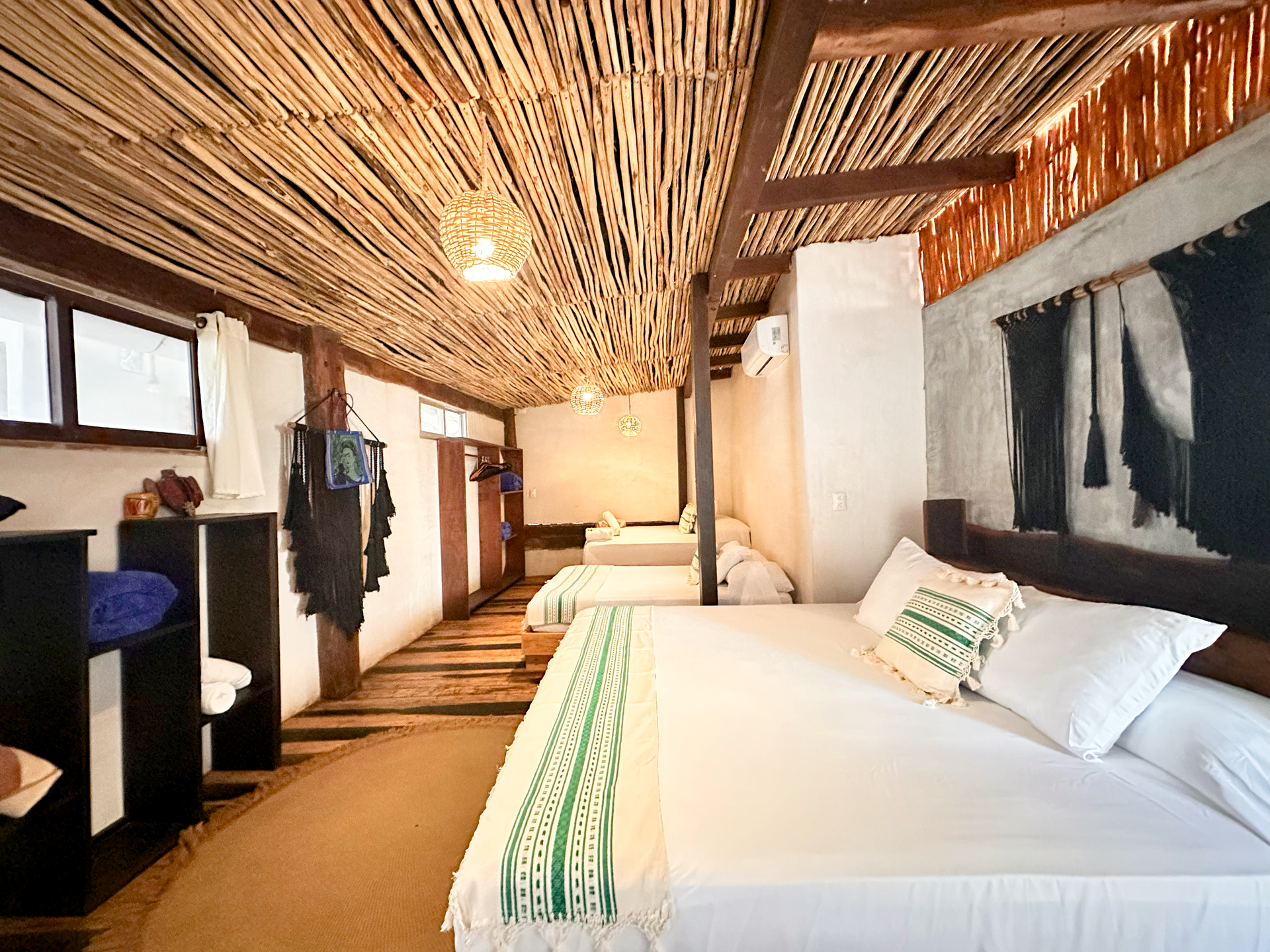 Cozy bedroom with a white bed, woven ceiling, and warm wood accents in a rustic interior