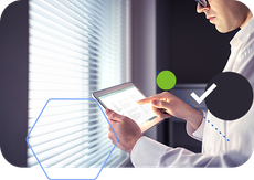 A man is using a tablet computer in front of a window.