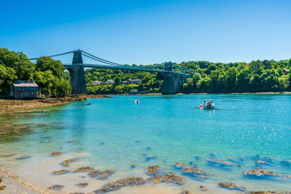 Boat In Water With A Bridge — Craig’s Lawn Mowing and Garden Maintenance in Menai, NSW