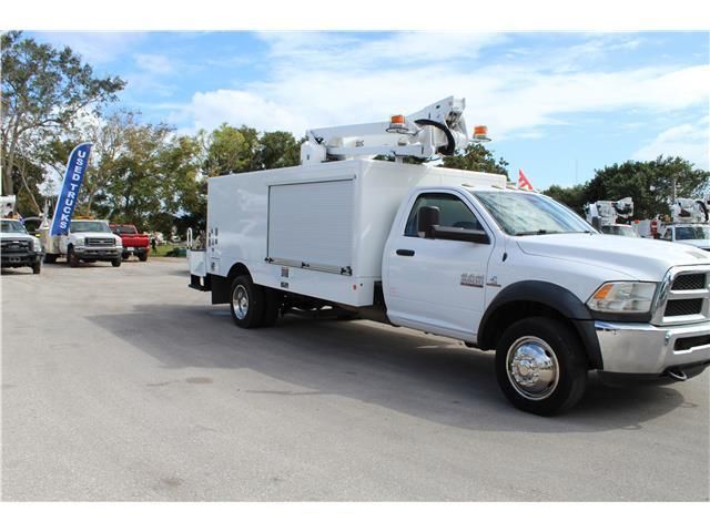 A white utility truck is parked in a parking lot