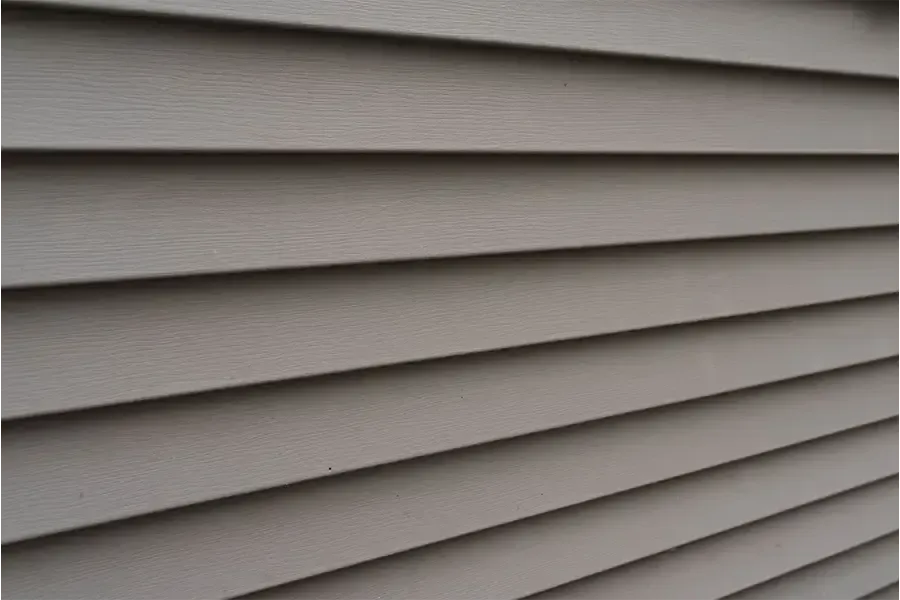 Close-up of gray horizontal vinyl siding on a building exterior.
