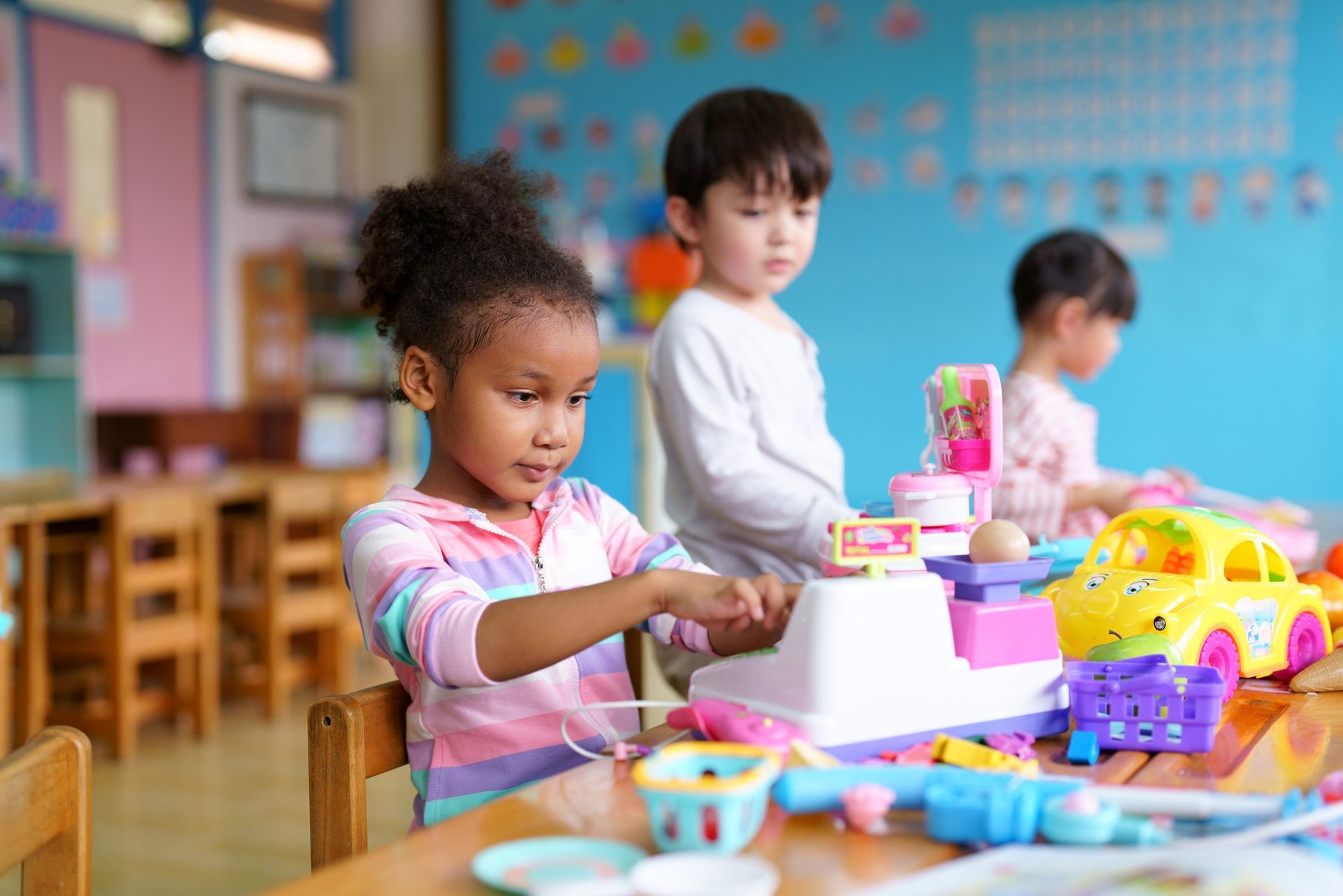 A group of children are playing with toys in a classroom.