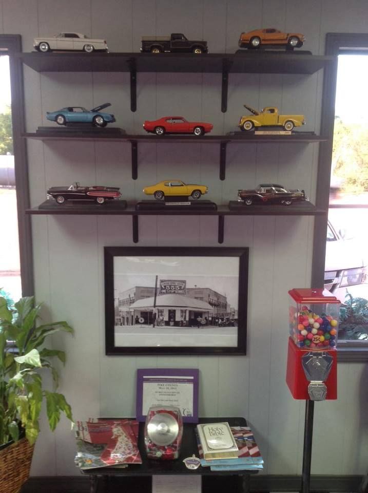 A picture of a gas station is on a wall next to a gumball machine