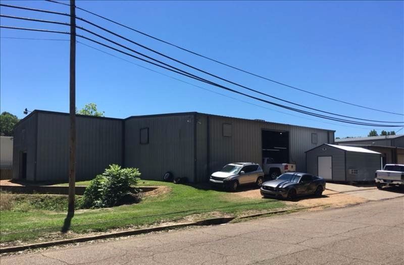 A row of cars are parked in front of a building