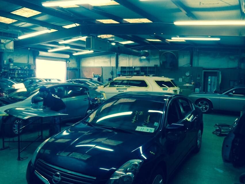 A nissan altima is parked in a garage with other cars