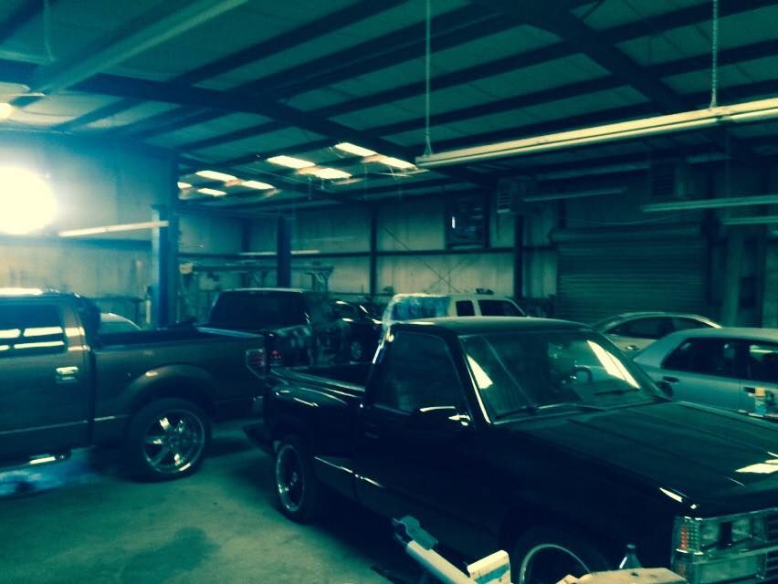 A row of black cars are parked in a garage