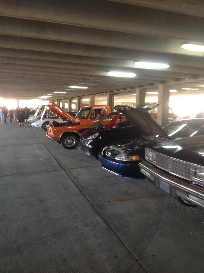 A row of cars are parked in a parking garage.