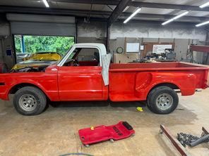 A red pickup truck is sitting in a garage.