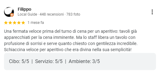 Screenshot di una recensione italiana che elogia il servizio veloce, il vino bianco e un aperitivo semplice, con le valutazioni visibili.