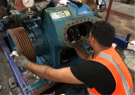 Mecánico inspeccionando la suspensión de un automóvil en un taller de reparación de automóviles.
