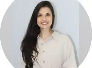 uma mulher com longos cabelos pretos está vestindo uma camisa branca e sorrindo.
